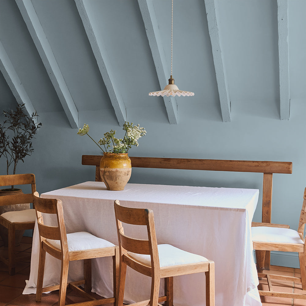 Grey-blue door in Lie-in Claypaint by COAT Paints with warm neutral wall and framed art