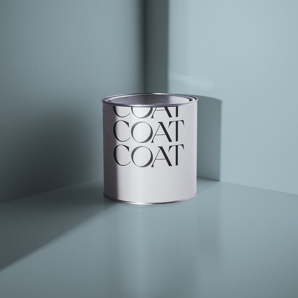 2.5L tin of Lie-in, a soft grey-blue Claypaint by COAT Paints, on a grey-blue surface