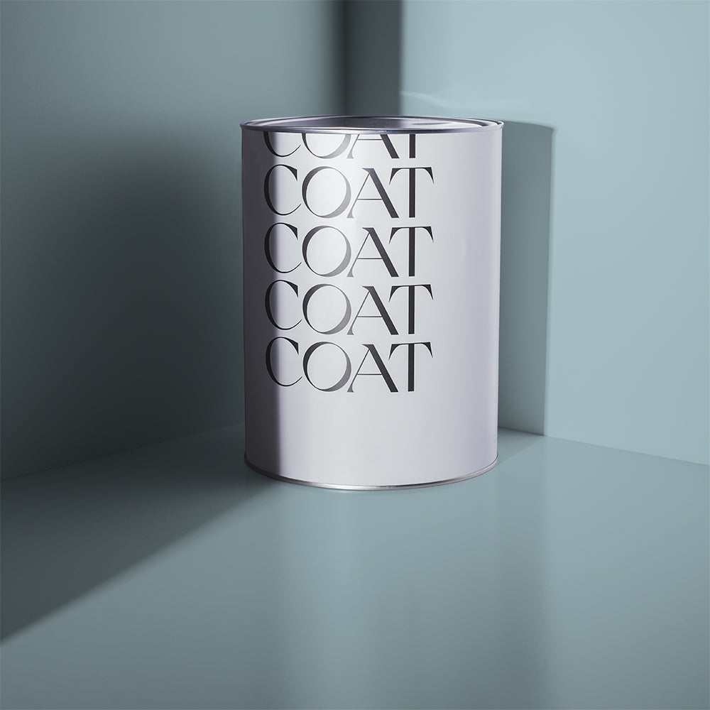 5L tin of Lie-in, a soft grey-blue Claypaint by COAT Paints, against a grey-blue background